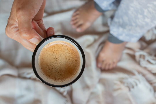 taza de caf&eacute; con espuma en manos de una mujer, vista cenital
