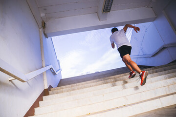 Young man running sprinting up stairs. Fit runner fitness runner during outdoor workout. Selected...