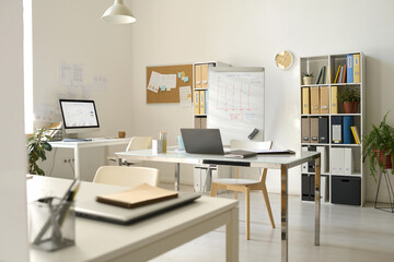 Modern office with workplaces with computers and flipchart for presentation