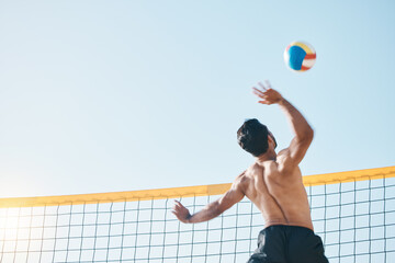 Volleyball, man and spiking, net with sports and fitness outdoor, playing game with blue sky and summer. Exercise, male athlete and match with ball and active, workout and action with tournament