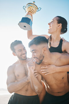 Celebration, winning and volleyball team on the beach with a trophy for goals, success or achievement. Happy, celebrate and group of athletes in unity together by ocean or sea on summer weekend trip.