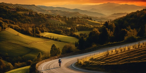 cyclist rides a winding stretch across fields on a long road