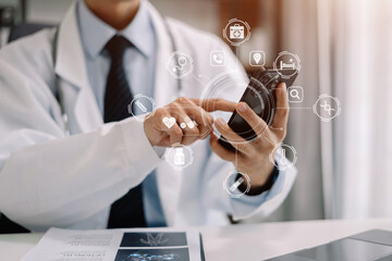 Medical technology concept. Doctor working with mobile phone and stethoscope and digital tablet laptop in modern office at hospital in morning light.