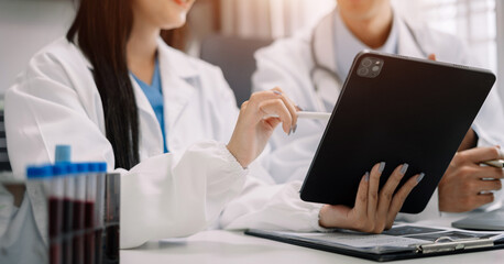 Doctors working together on digital tablet healthcare doctor technology tablet using computer in a modern office.