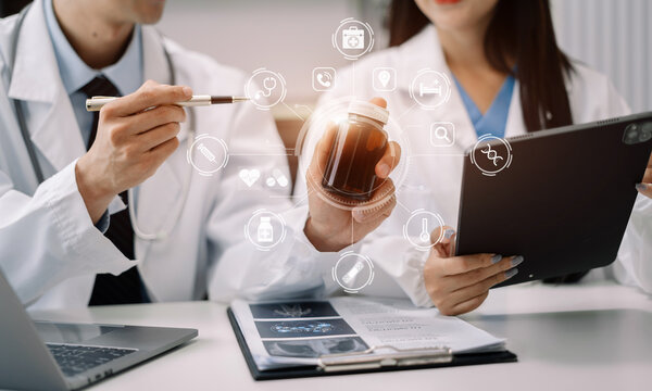 Pharmacists or doctors study information about tablets in the operating room in the evening.