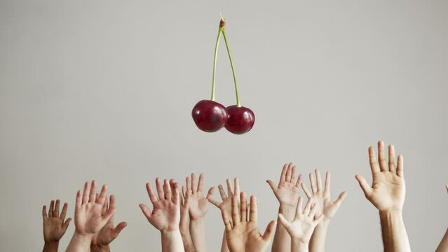 The cherry revolves over the crowd from the hands, The idea of aspirations and goals. The concept of concentrating the common interest of a group of people.