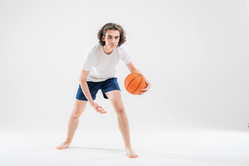 Fototapeta na wymiar Portrait of a boy playing with a basketball on a white background