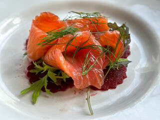 Trout gravlax with beet slices and served with dill. Scandinavian meal with red fish (Gravadlax , graavilohi). Trout gravlax with beet slices and served with dill
