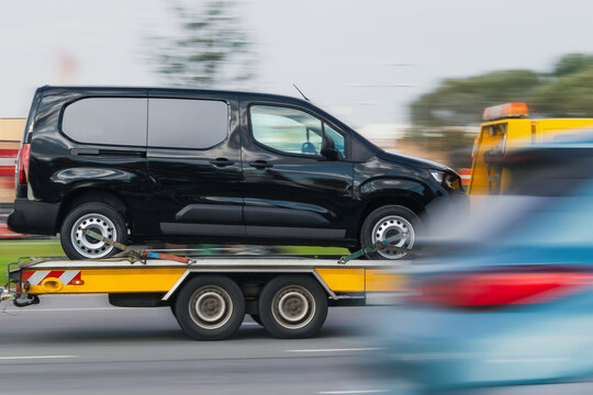 Car tow truck. Tow truck transports a car, blurred background. Car evacuation, car service concept, roadside assistance. Motion blur