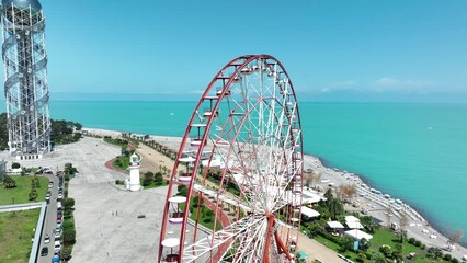 Aerial shot of Ferris wheel, alphabetic tower, skyscrapers and embankment of Batumi city