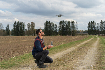Naklejka na ściany i meble A man launches a mini drone in nature.