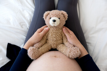출산을 기다리는 임산부가 곰인형을 안고있다