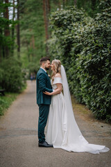 Bride and groom. The bride is dressed in a long very beautiful wedding dress, holding a bouquet of flowers