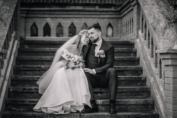 Sensual romantic newlywed couple sitting on old baroque stairs