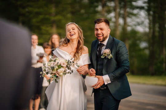 Romantic young bride and groom holding hands and laughing