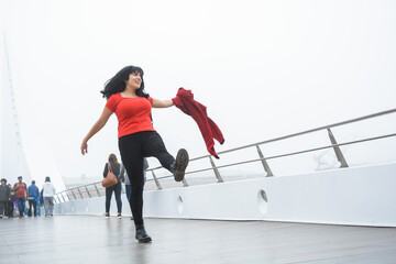 young tourist woman walking and jumping happily on the Puente De La Mujer in Buenos Aires.