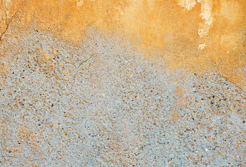 Background of old plaster with remnants of ocher color paint