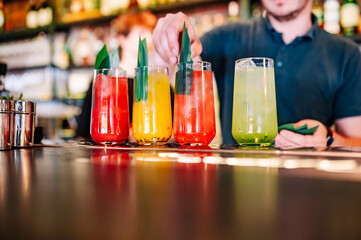 bartender making cocktail in glass on the bar counter