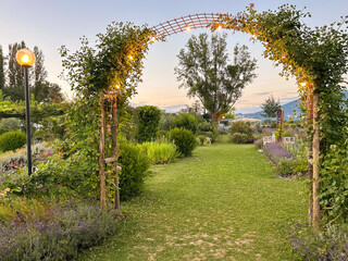 View of romantic garden with arch at sunset in Assisi, Umbria region, Italy - 619820948