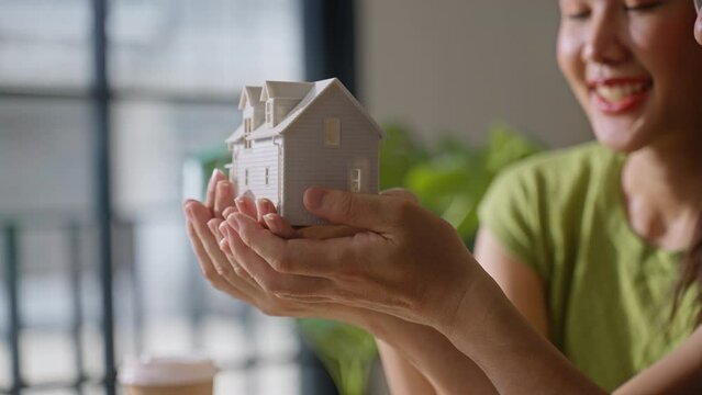 house happy family.friendly family hands holding model house at home,house dreams,mortgage business construction concept lifestyle. 
