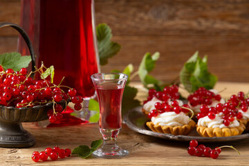 Delicious homemade currant liqueur. Served in a glass and carafe. Served with currant cake.