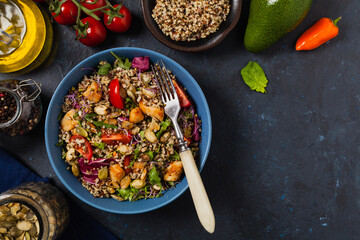 Salad with quinoa, avocado and chicken. Top view. Served in a blue bowl.