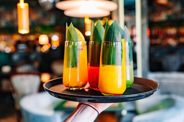 glasses lemonade cocktail set on a waiter tray in bar