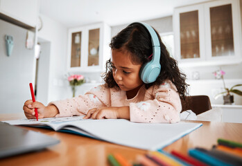 Young child, learning and homeschool with headphones for homework, writing and drawing in books....
