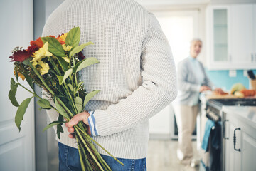 Senior, couple and flowers for love in home, kitchen or husband with bouquet of roses to surprise woman in happy marriage. Man, wife and back hiding gift, flower and romance together on anniversary