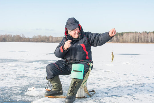In winter, a man fishes on a frozen river.