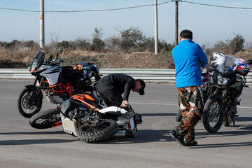 Off road motorcycle driving instructor teaching his students what to do when the vehicle falls to the ground. 