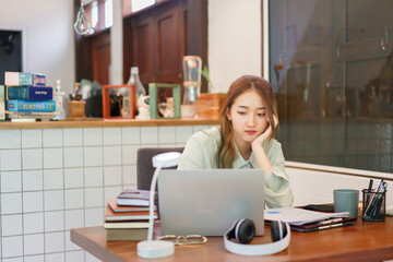 Coworking space office concept, Woman entrepreneur feeling exhausted while reading data on laptop