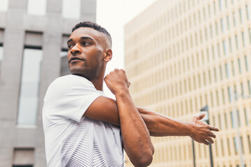 Black man stretching arms on street