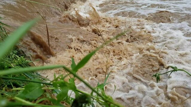 Muddy dirty water mixed with sewage flowing after heavy rains and floods in the city	
