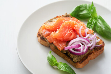 Sandwiches with salted salmon, avocado guacamole, red onions and basil. Smorrebrod. Set of danish open sandwiches. Healthy food, breakfast. Clean eating, dieting, vegan food concept. Top view.