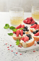 American flag sandwich with strawberries, blueberries, whipped sweet cream, soft cheese on toast bread. 4th of July American Independence Day food. Independence or Patriotic Day breakfast idea Mock up