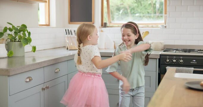 Jumping, dance and girl kids in the kitchen playing and bonding with energy in a modern home. Happy, playful and children friends dancing and having fun together to music, playlist or album in house.