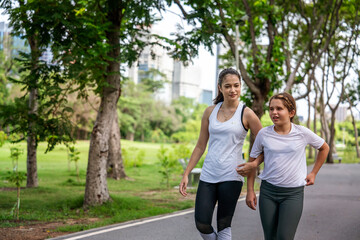 Indian woman is a fitness instructor walking an eight-year-old girl together in the garden in the morning
