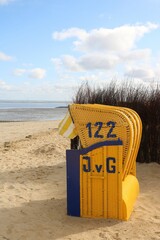 Ein einsamer Strandkorb am Strand der Nordsee in Cuxhaven Duhnen mit Blick aufs Meer