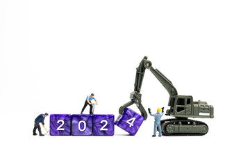 Fototapeta premium Miniature people , Worker team flips a block with the number 2024, On a white background