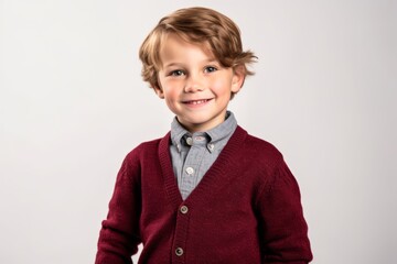 Portrait of a cute little boy with blond hair in a burgundy sweater.
