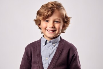 Portrait of a cute little boy with blond curly hair on gray background
