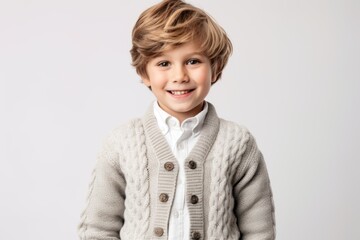 Portrait of a smiling little boy in a knitted sweater on a white background