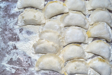 many dumplings lying on the table are glued with their own hands