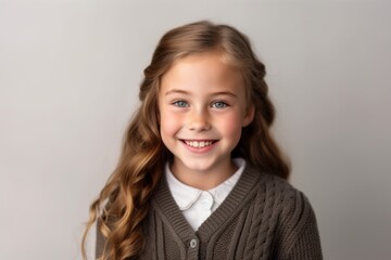 Obraz premium Portrait of a cute little girl with long hair on a gray background