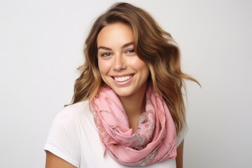 Fototapeta premium Portrait of a beautiful young woman with pink scarf on white background