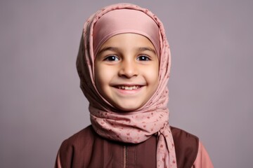 Portrait of a cute little muslim girl wearing a pink hijab