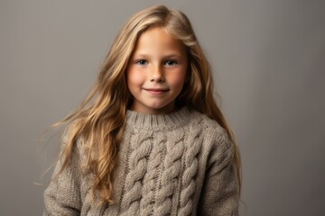 Portrait of a cute little girl with long blond hair in a gray sweater