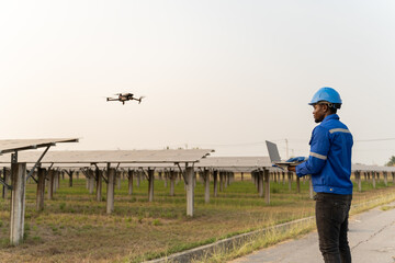 African american specialist technician professional engineercontrol drone checking top view of installing solar panel farm on the factory under sunlight. Engineers holding tablet check solar farm.