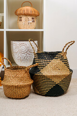 White shelving with  various baskets. Seagrass Belly basket , Cloth, and wicker  baskets for...